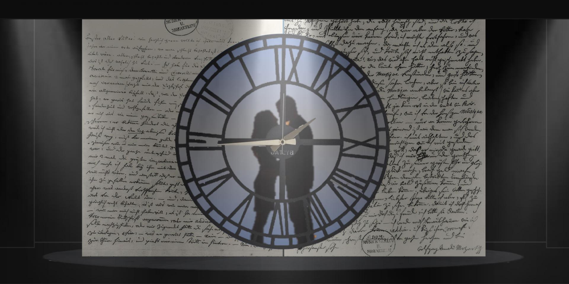 Un grande orologio attraverso il quale si vedono in controluce le sagome di due persone che si abbracciano