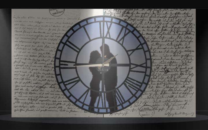 Un grande orologio attraverso il quale si vedono in controluce le sagome di due persone che si abbracciano