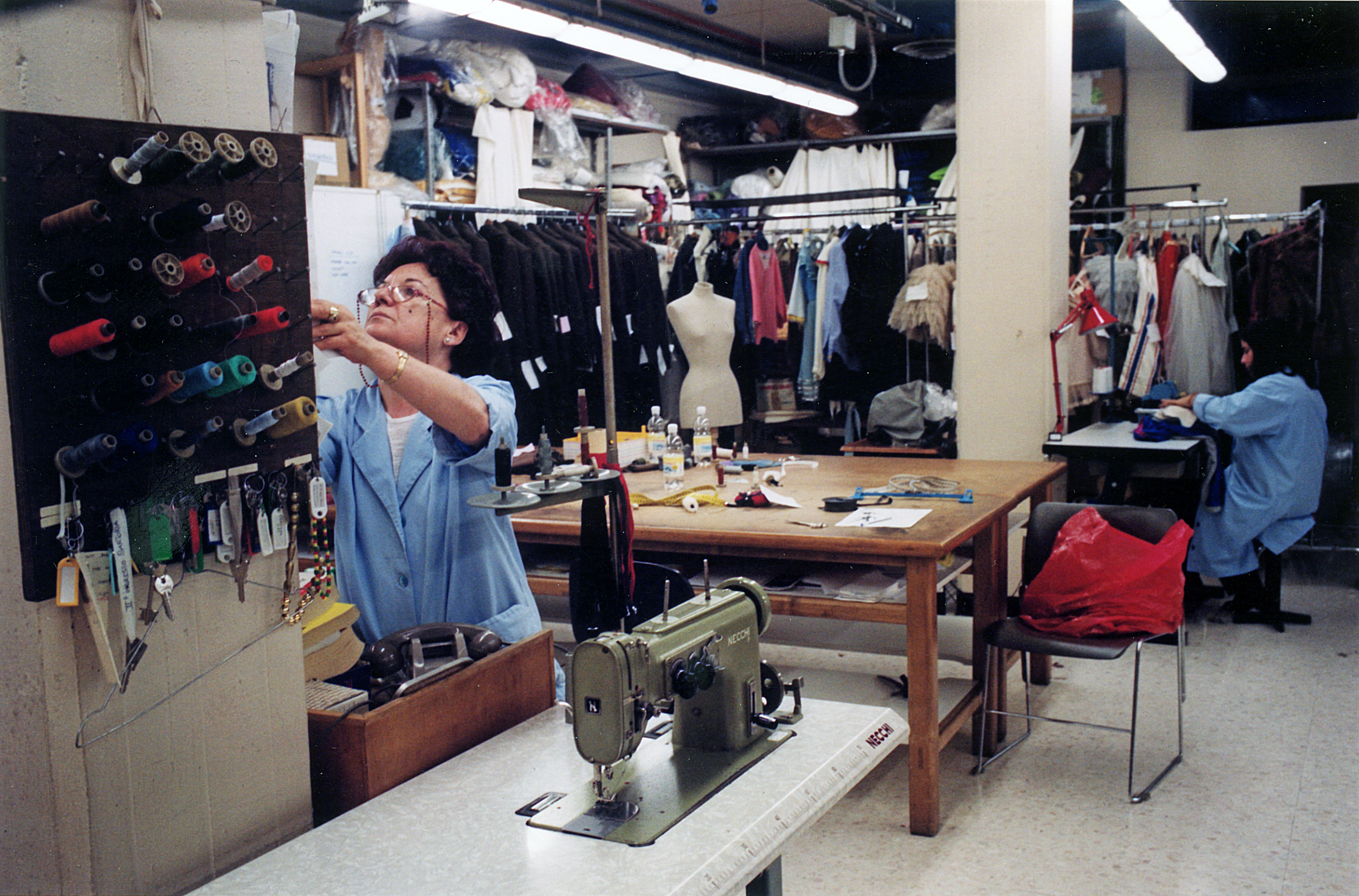 A view of the costume workshop in the midst of reels, sewing machines and clothes hangers